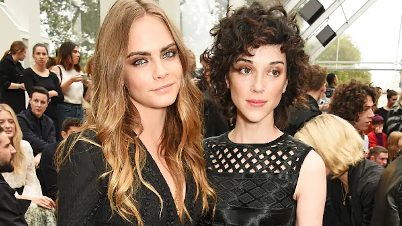 LONDON, ENGLAND - SEPTEMBER 21: Cara Delevingne (L) and Annie Clark attend the Burberry Womenswear Spring/Summer 2016 show during London Fashion Week at Kensington Gardens on September 21, 2015 in London, England. (Photo by David M. Benett/Dave Benett/Getty Images for Burberry)