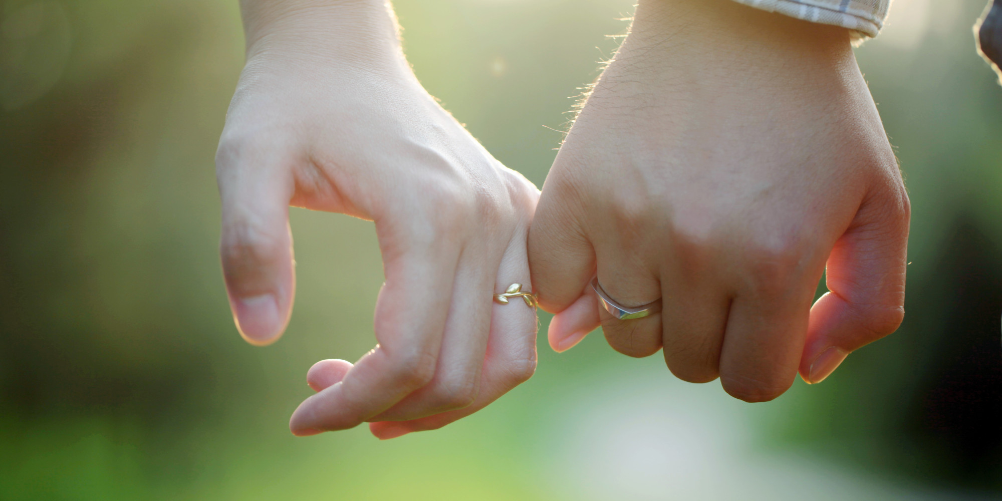 Young couple wearing rings hand in hand